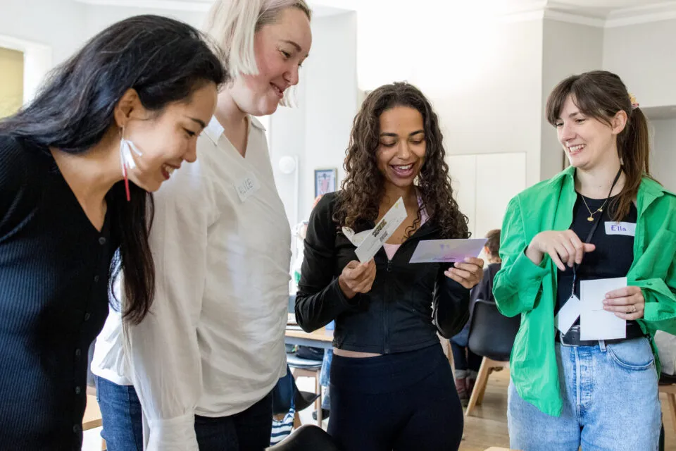 Four people taking part in an SSE programme. They are standing up and smiling while looking.